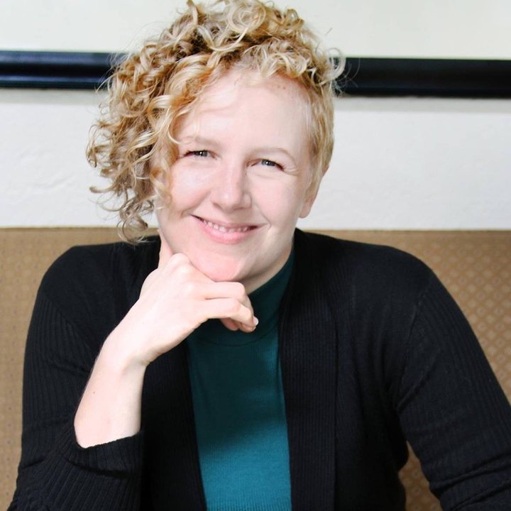 Amber Bradshaw, smiling, chin resting on one hand